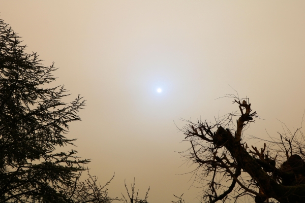 Le soleil joue à cache-cache derrière le nuage de sable